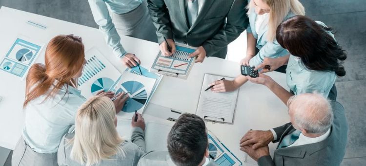 Especialistas multifuncionais ao redor de uma mesa atuando em um projeto em uma empresa